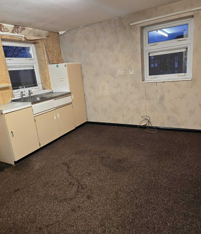 Partially stripped kitchen space requiring removal of units and final clearance.