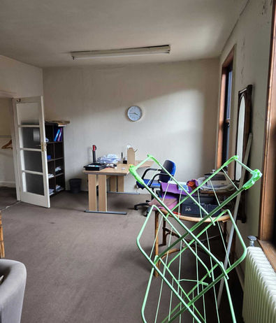 Office space with desk, chairs, mirror and assorted paperwork requiring commercial clearance.