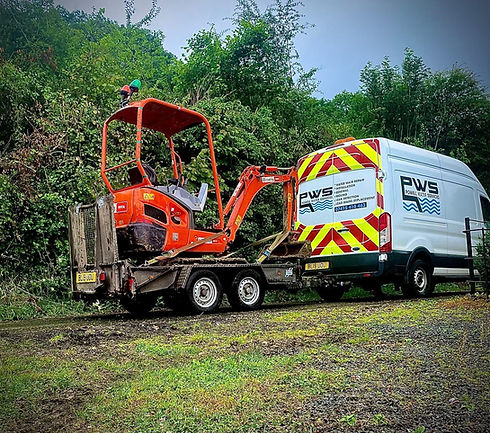 White van towing a digger