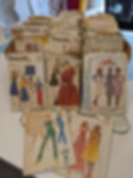 A cardboard box filled with vintage sewing patterns.