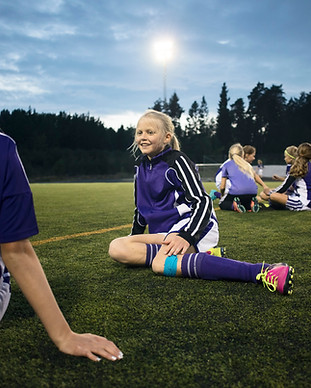 Girls Relaxing on Soccer Field