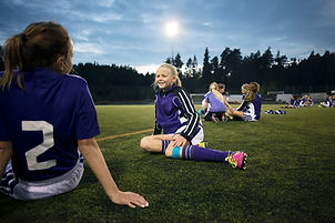 Girls Relaxing on Soccer Field