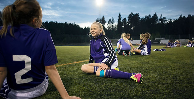 Girls Relaxing on Soccer Field