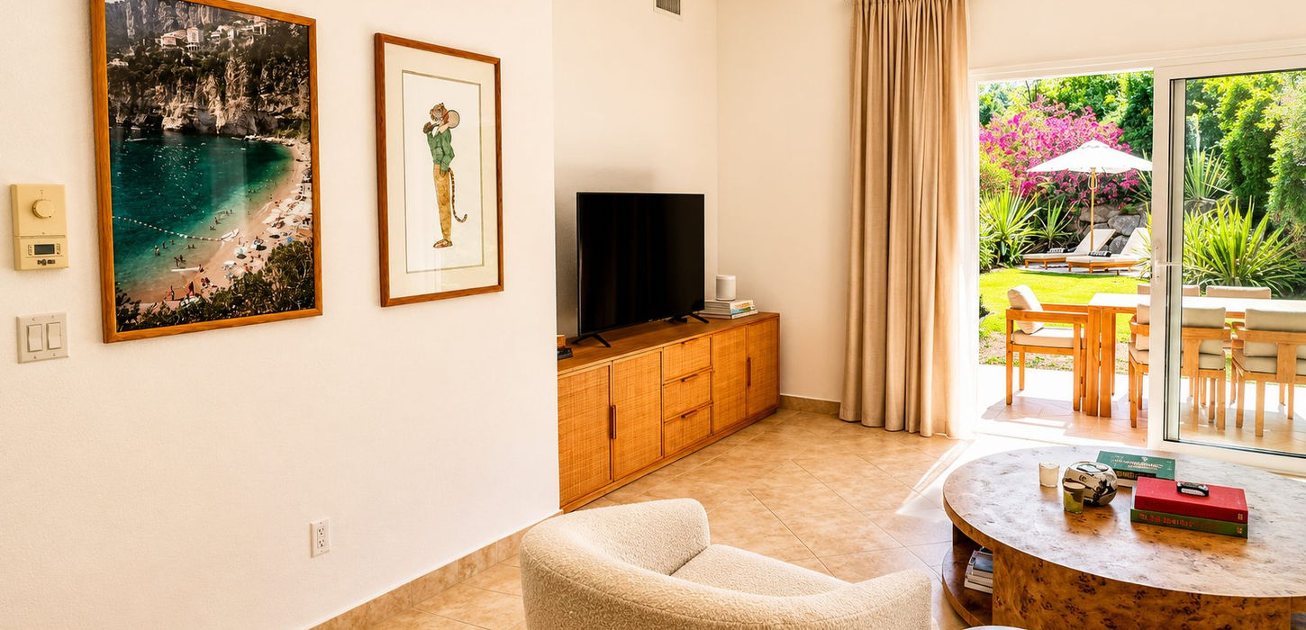 Bright garden-view living room with direct patio access at Porto Cupecoy condo for sale in Sint Maarten