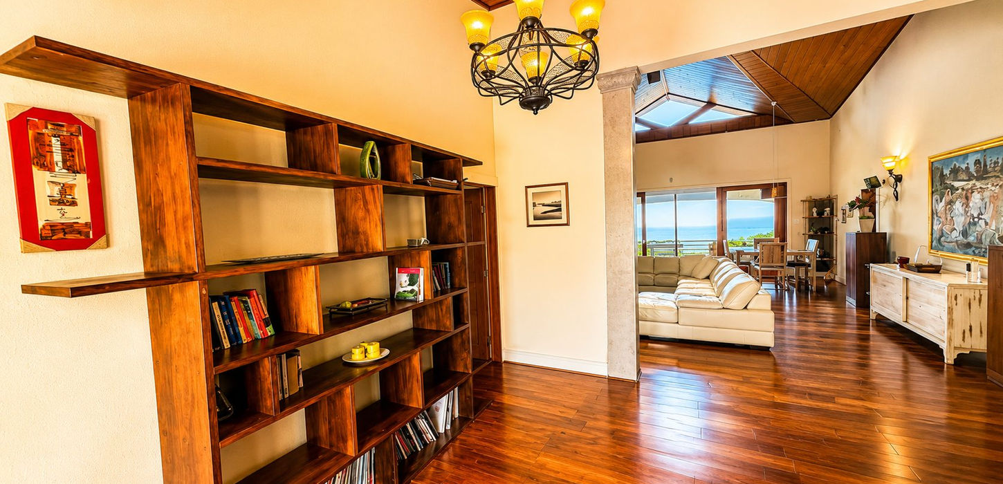 Open-concept living and dining area with vaulted ceilings, custom wood flooring, gourmet kitchen, and ocean views in a luxury Sint Maarten villa.