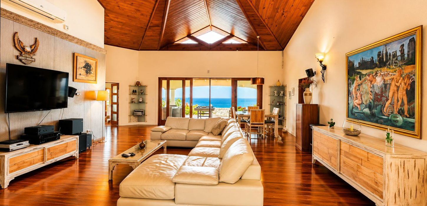 Elegant living room featuring dramatic vaulted wood ceilings, natural light, ocean views, and spacious open-plan design.