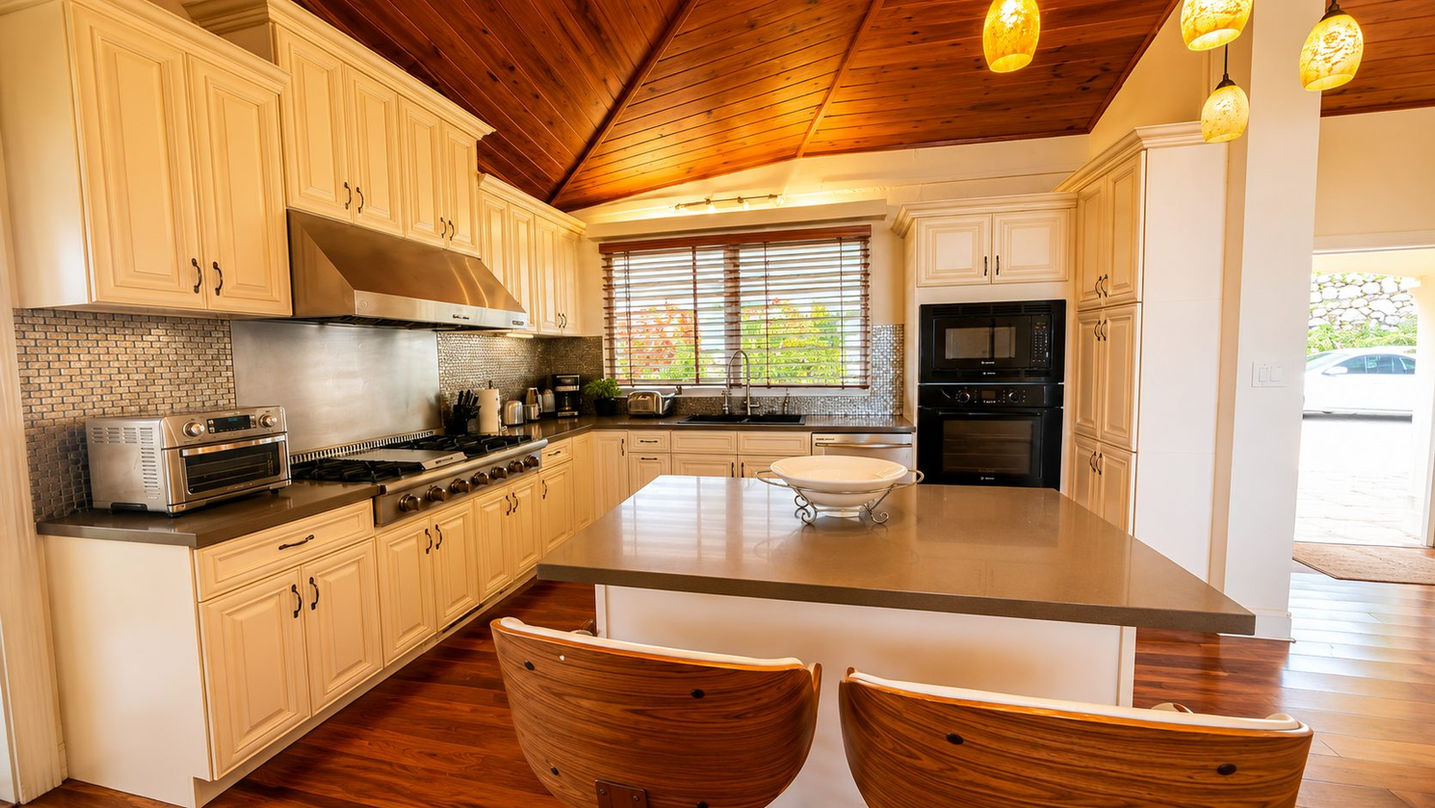 Spacious chef’s kitchen with custom cabinetry, large island, premium appliances, vaulted wood ceilings, and ocean views in a luxury Sint Maarten home.