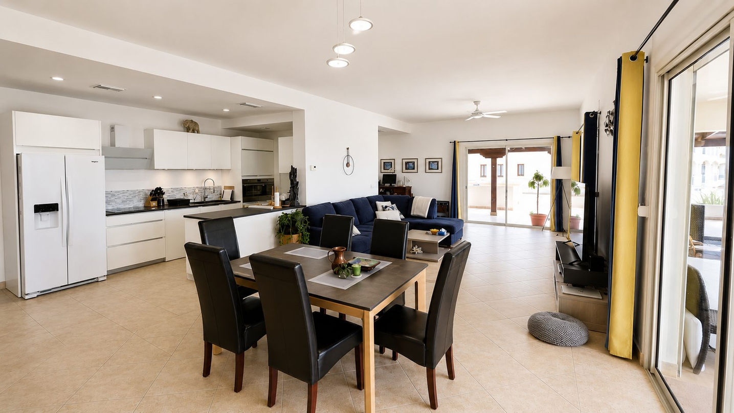 Open-concept living room, dining area and modern kitchen in a luxury condo for sale in Porto Cupecoy, St. Maarten.