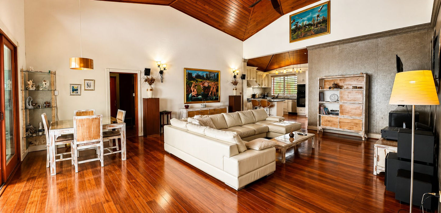 Elegant entertainment space with home theater system, designer furniture, vaulted ceilings, and premium finishes in a luxury Caribbean villa.