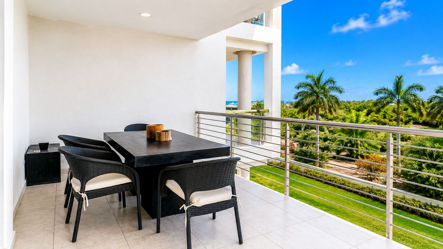 Covered terrace dining area in St Maarten condo for sale with tropical garden and ocean views