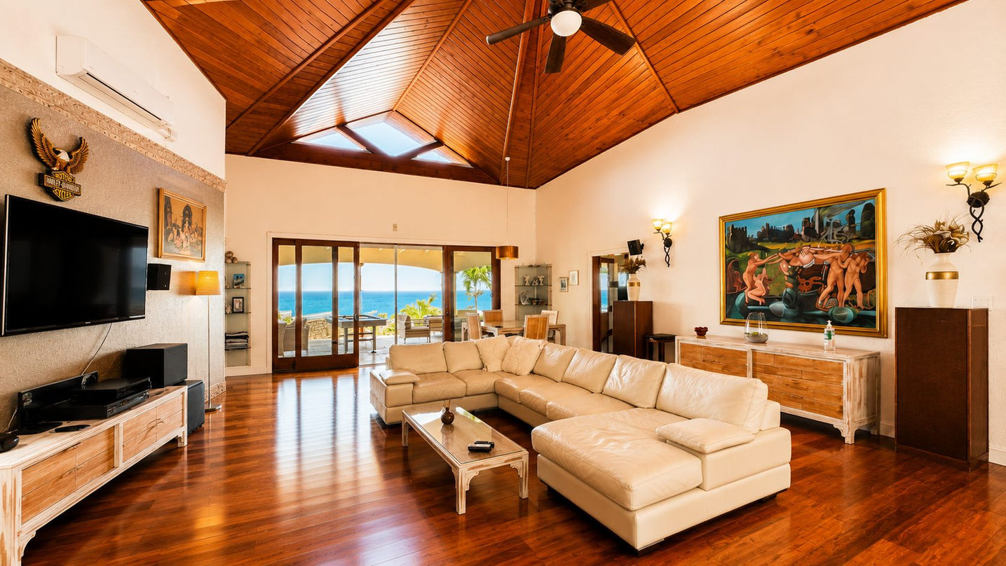 arge luxury living area with vaulted ceilings, designer décor, ocean-view terrace, and premium finishes in a St. Maarten villa.