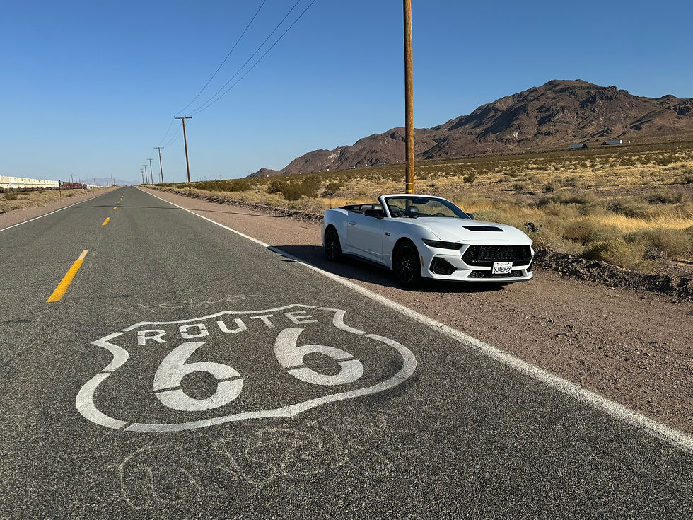 High angle view of a Ford Mustang parked near a desert roadside with Route 66 sign