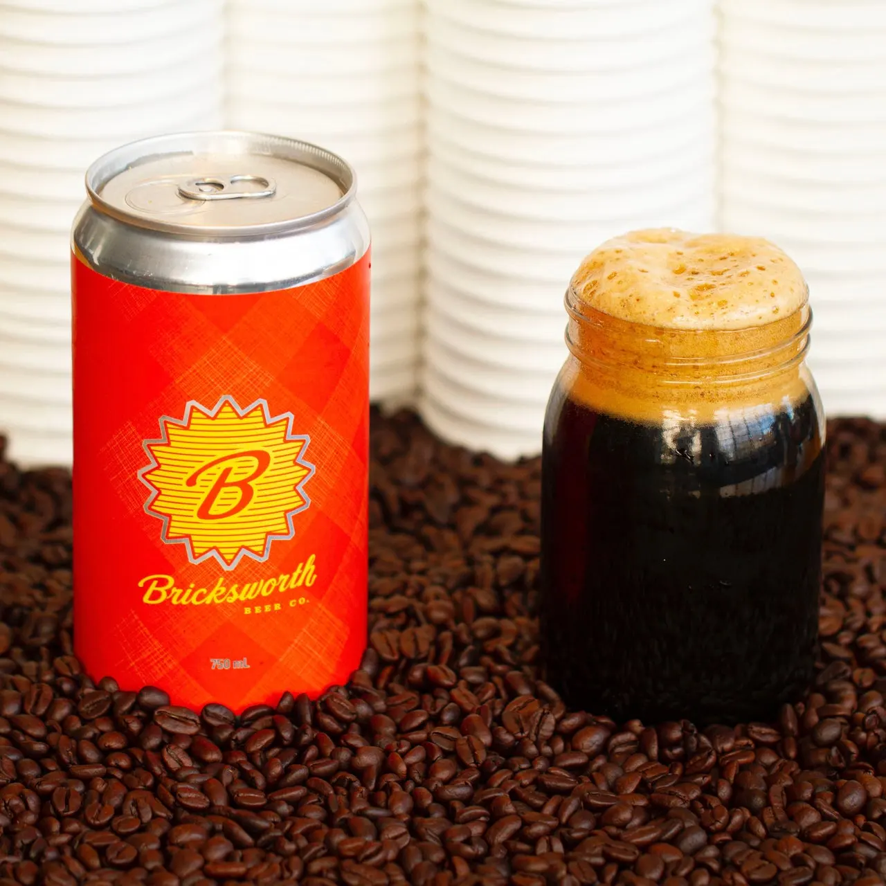 image of a dark beer in a jar next to a Bricksworth Beer Co. can