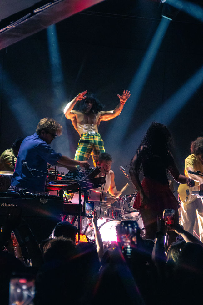 Energetic band performing on stage with vibrant lighting.