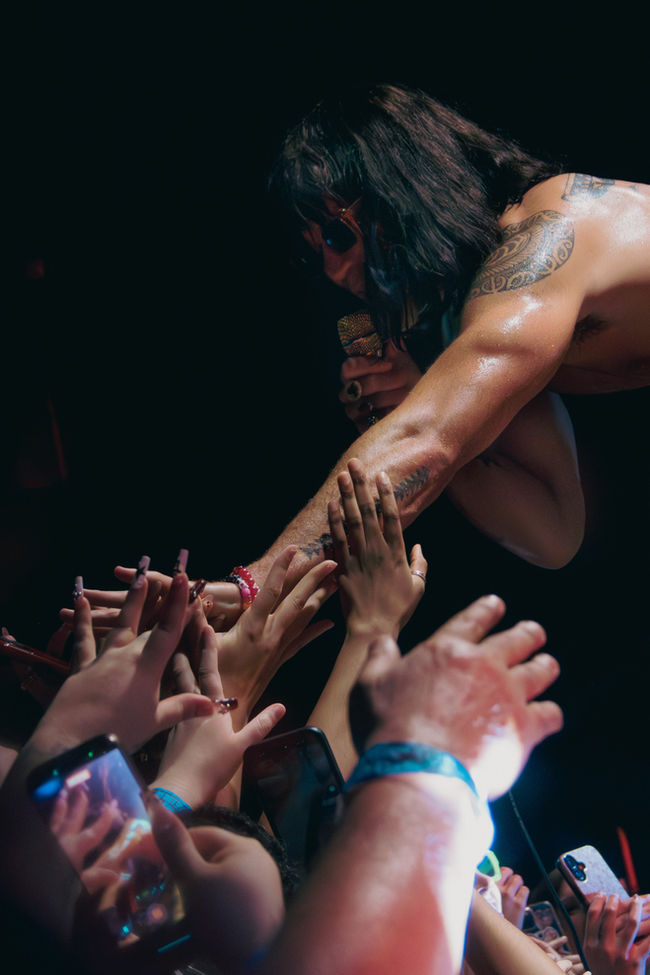 Performer reaching out to audience during concert.