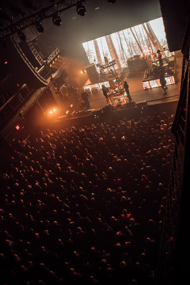 Concert crowd and stage with dramatic lighting.