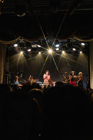 Band performing on stage with bright lights.