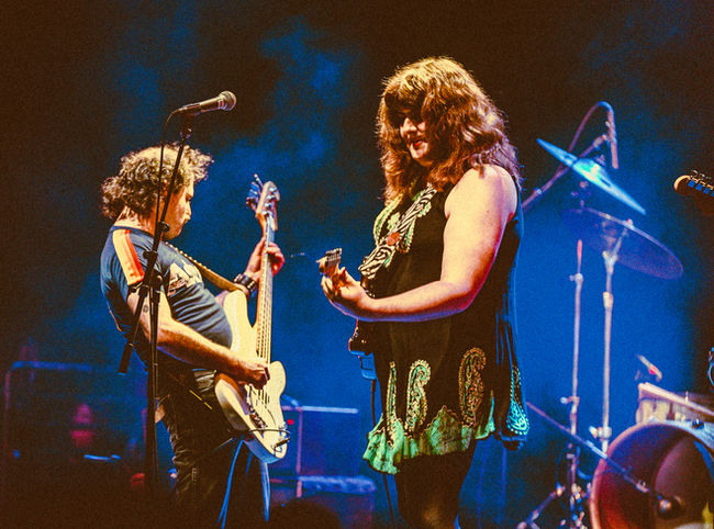 Two musicians performing energetically on stage.