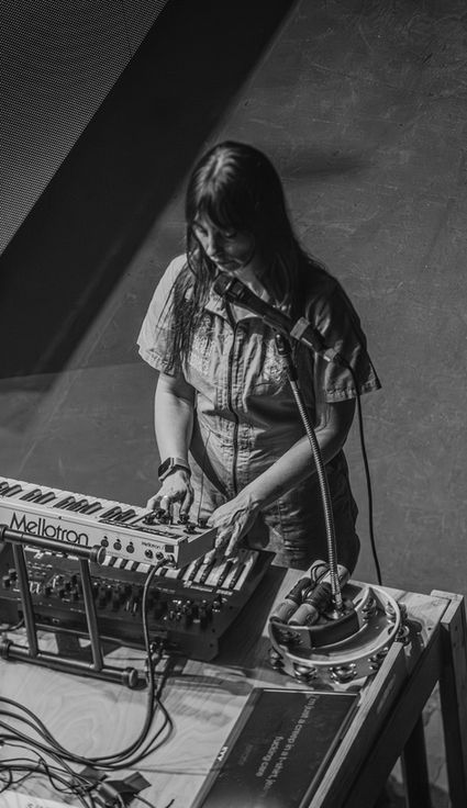 Musician playing keyboard and singing into a microphone.