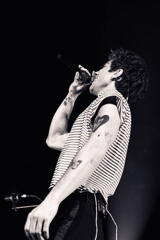 Black and white photo of a person singing passionately.