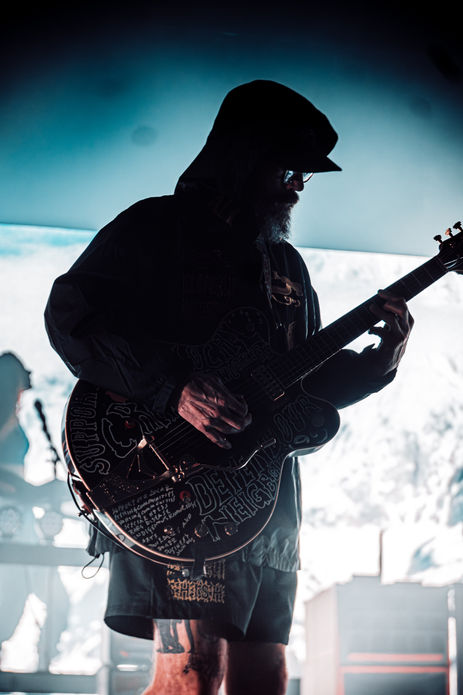 Silhouetted musician playing guitar on stage.