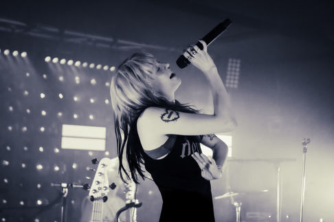 Singer passionately performing on stage with microphone.
