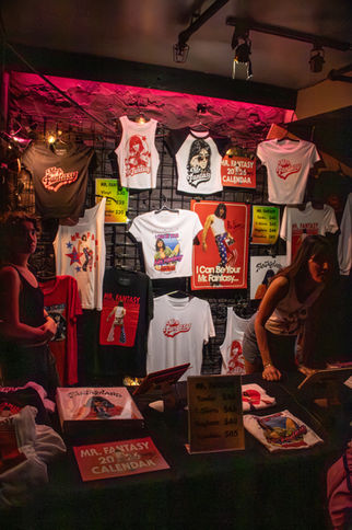 Merchandise booth with colorful t-shirts and posters.