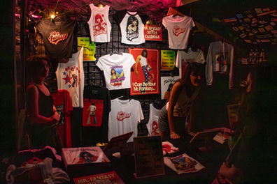 Merchandise booth with colorful shirts and posters displayed.