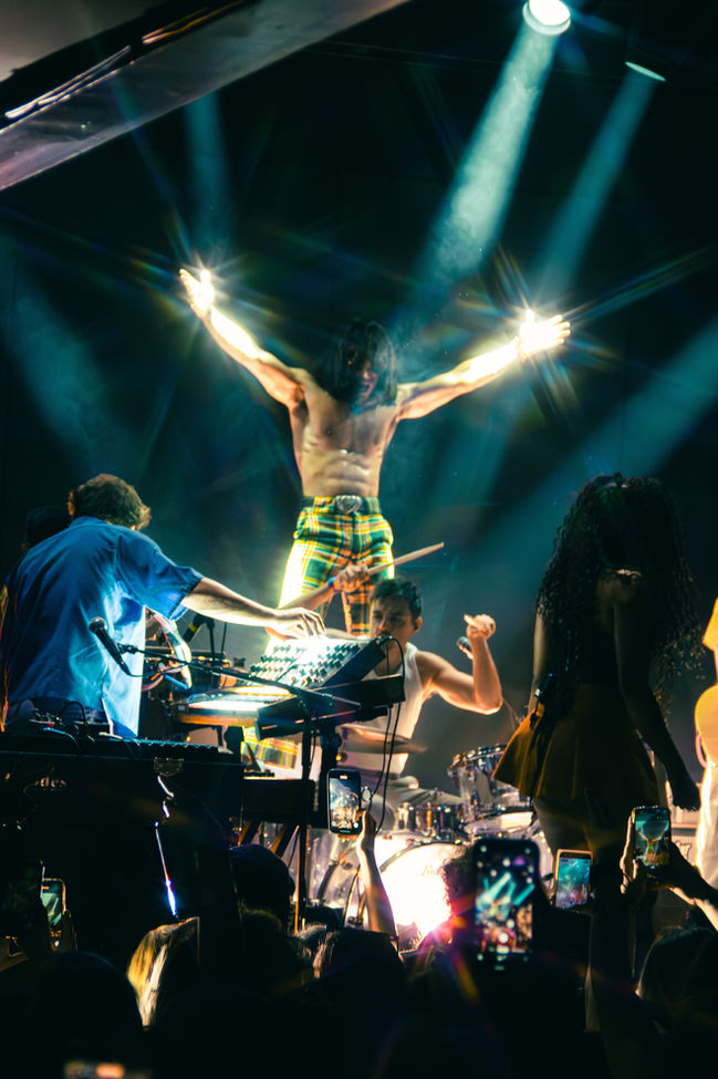 Concert performance with dynamic lighting and musicians on stage.