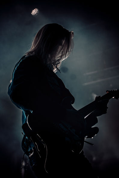 Silhouette of a guitarist playing on stage.