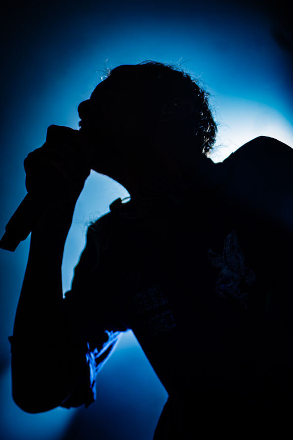 Silhouette of a singer with a microphone, blue background.