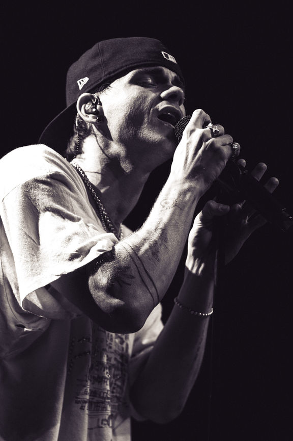 Black and white image of a person singing passionately.