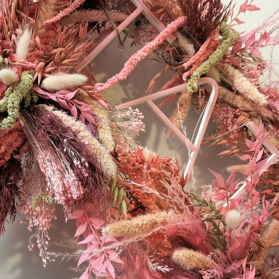 Pink dried flowers surrounding a neon light