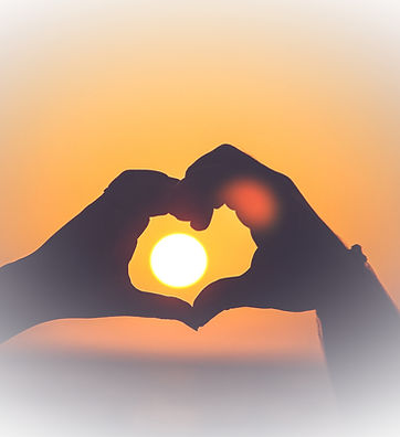 Hands forming a heart shape at sunset, representing love, connection, and emotional wellbeing counselling