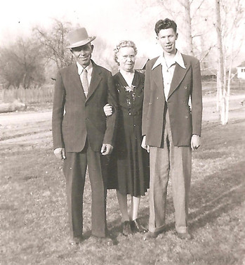 Young Glade Peterson standing outdoors between his parents, Hans William Peterson and Margaret Keddie Adamson, around 1946.