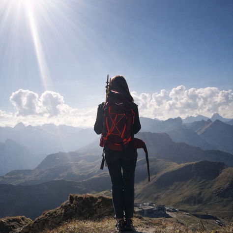 Person standing alone in the mountains during a sabbatical, reflecting on slowing down and personal change