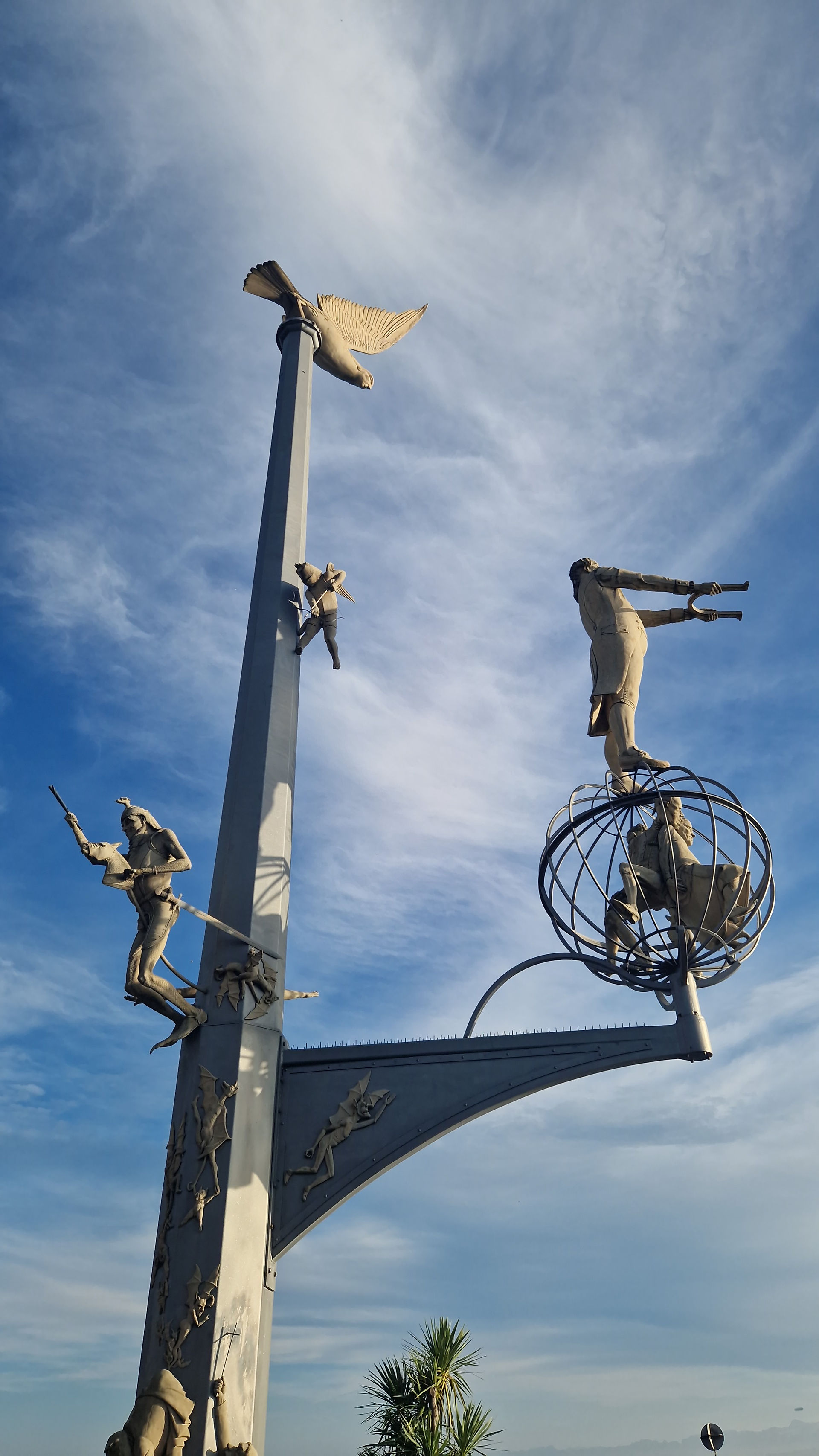 “Magische Säule” sculpture at Meersburg harbor against a clear blue sky.