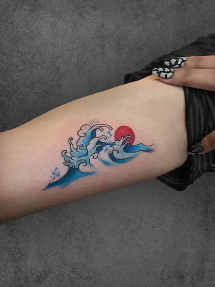 A colorful depiction of ocean waves in a Japanese style, with a red sun in the background, evoking serenity and strength
