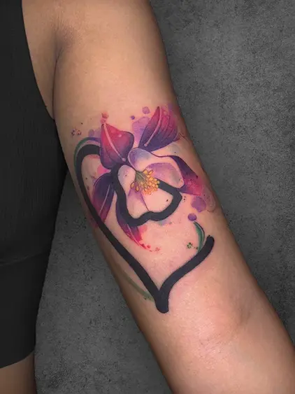 A vibrant watercolor tattoo of a flower framed within a heart shape, symbolizing love and beauty, designed by a student of the Complete Course in Tattoo