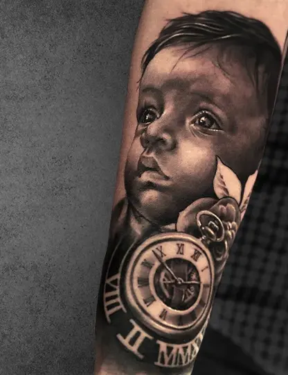 Realistic baby portrait tattoo with a clock and rose on the forearm, black and grey style