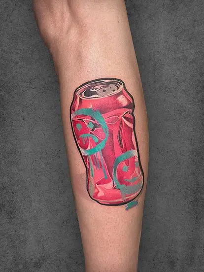  A vibrant and playful color tattoo of a crushed soda can with turquoise graffiti accents, placed on the leg. This piece brings a pop of color and urban art style. Created by students of Aliens School of Tattoo Art