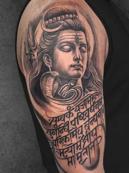 Peaceful Shiva with Sanskrit mantra upper arm tattoo, male-oriented, black and grey realism style by Aliens Tattoo