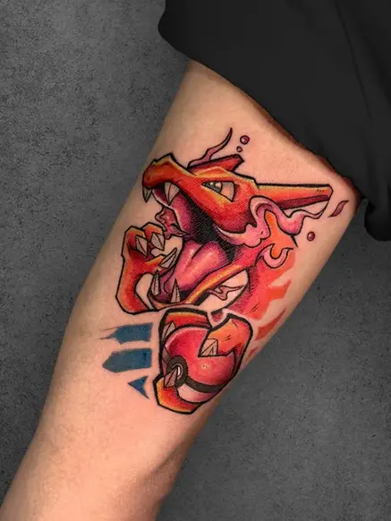  Vibrant red and orange Charizard tattoo with flames, cartoon style, on the forearm of a male.