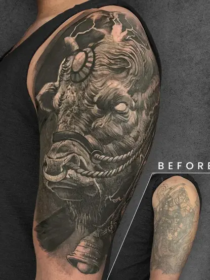 A highly detailed bull tattoo on the upper arm, featuring intense shading and dramatic elements. The design effectively conceals a heavily outlined tattoo visible in the inset.