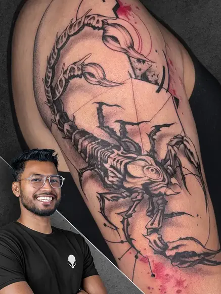 Picture of tattoo artist Jotish Roy with A dynamic tattoo of a scorpion with geometric and abstract patterns, done in a neo-traditional style on the upper arm in the background