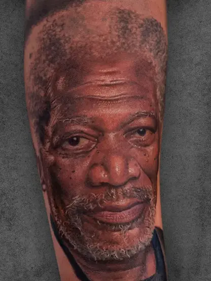 "Hyper-realistic portrait tattoo of Morgan Freeman, showcasing detailed textures and lifelike colors on the forearm