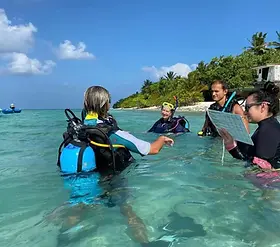 Master Scuba Diver Trainer teaching a group of students during a PADI training session at Maldivian Academy of Diving, Himmafushi, Maldives.