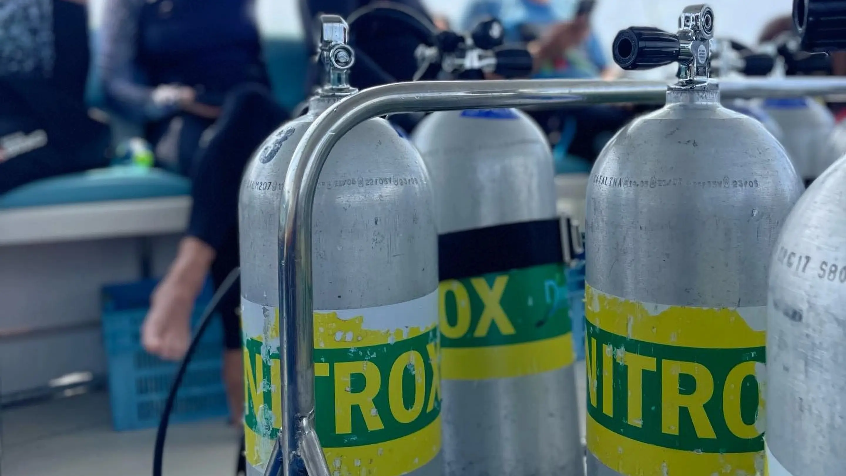 PADI Enriched Air Diver course setup showing scuba tanks labeled for nitrox on a dive boat with Dive Desk Male' and the Maldivian Academy of Diving Himmafushi in the Maldives.