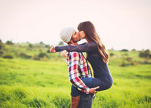 Man holding up woman and kissing