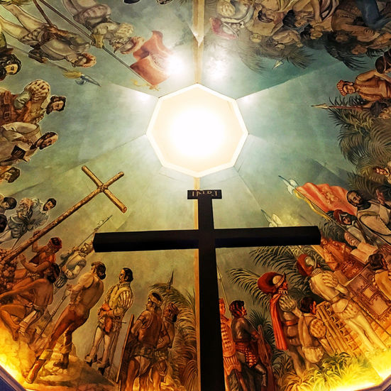 Magellan’s Cross in Cebu with a large wooden cross under a dome painted with historical murals